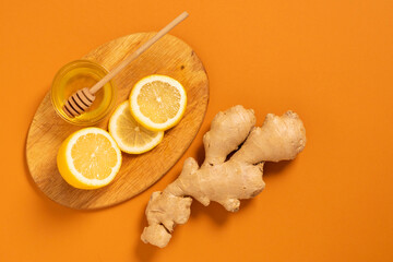 Fresh ginger root lemon honey orange background. Alternative medicine vegetarianism