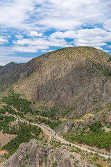 aerial view of road crossing high mountain, sky clouds landscape