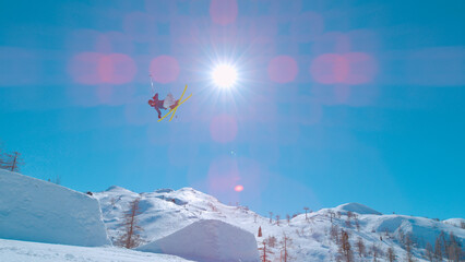 LOW ANGLE VIEW: Extreme freestyle skier flying through air after jumping big air