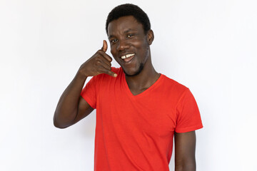 Portrait of happy African American man with call me sign. Excited young male model with short dark hair in red T-shirt looking at camera, asking to call him. Advertisement, communication concept