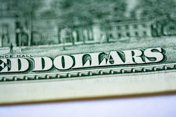 The inscription "dollars" close-up on a paper bill of the old 100 American dollars. Macro photo with beautiful bokeh.