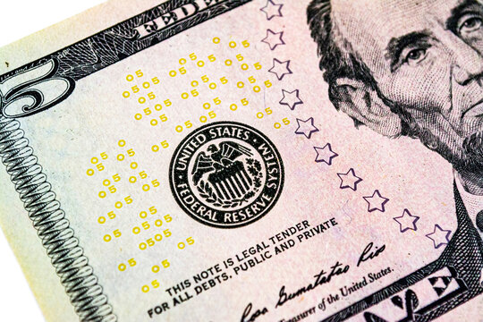 Symbol of the US Federal Reserve System on the US 5 dollar bill. Fed emblem close-up on american currency.