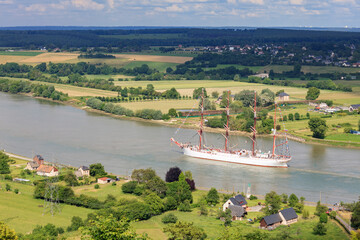 HEURTEAUVILLE, NORMANDY, FRANCE: russian tall ship Sedov sails from Rouen to the English Channel, on the Seine River, among green lush countryside landscape - obrazy, fototapety, plakaty
