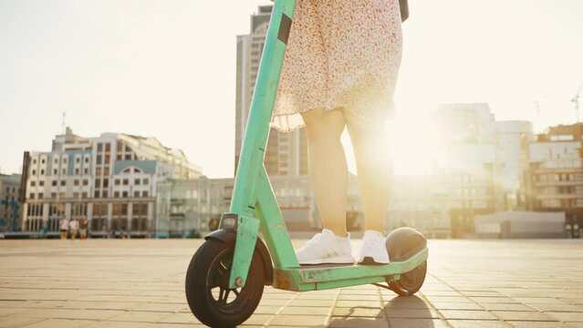 Young woman on an electric scooter having fun rides through the city streets