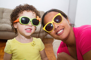 Close up biracial family portrait loving black mother and caucasian daughter at home smiling and happy. Mother's love for the affectionate child