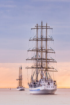 HONFLEUR, NORMANDY, FRANCE: Armada 2019 Grande Parade, tall ships Mir and Santa Maria Manuela sailing away from the Seine Estuary in the setting sun