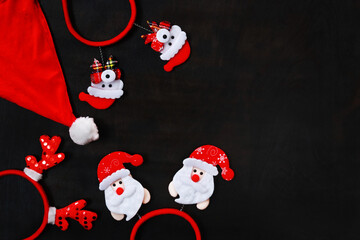 New year banner with holiday accessories and blank space for text. Top view of a New Year's toys, decor on black wooden table