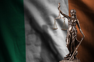 Ireland flag with statue of lady justice and judicial scales in dark room. Concept of judgement and...