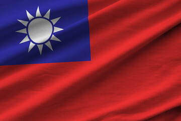 Taiwan flag with big folds waving close up under the studio light indoors. The official symbols and colors in banner
