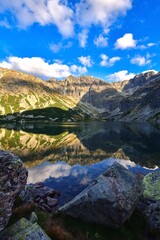 Fototapeta na wymiar Wonderful mountain summer landscape. Mountain peaks reflecting in a beautiful lake. Photo taken in the Gasienicowa Valley in the Polish Tatra Mountains.