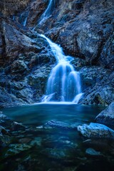 Beautiful waterfall with blurred water effect. Photo taken in the Valley of Five Ponds in the Polish Tatra Mountains. Long exposure photo.