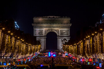 Paris, France - November 20, 2022: Christmas time, the decoration along the Avenue des Champs Elysees with Arc de Triomphe in background in Paris, France - obrazy, fototapety, plakaty