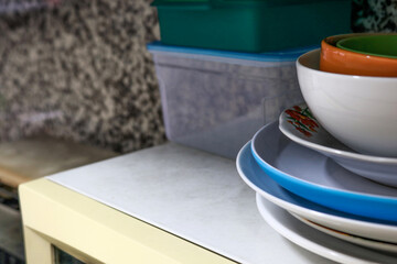 Piles of plates and glasses in the kitchen of an apartment or house
