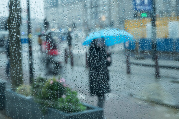 Fototapeta ludzie w deszczu na ulicach miasta obraz