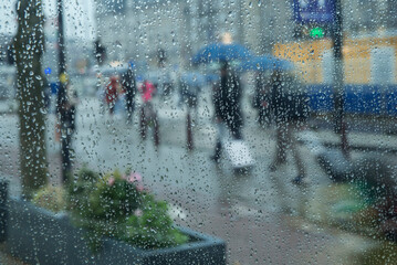 Fototapeta ludzie w deszczu na ulicy miasta obraz