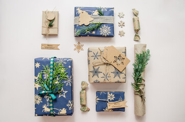 Eco friendly Christmas composition with gift boxes in craft reusable paper and natural decor on white background top view. Zero waste environmentally friendly Christmas concept.