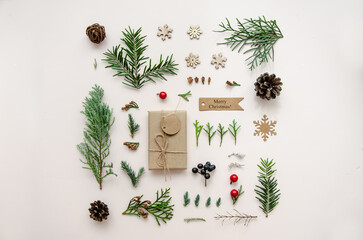 Christmas composition. Gift, fir tree, pine tree, cypress branches and cones, decorations on white background. Christmas, winter, new year concept. Flat lay, top view, copy space.