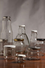 photo of reusable glass containers for food storage - bottles and jars on a wooden table