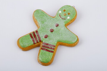 Green frosted gingerbread man Christmas tree ornament on a white background
