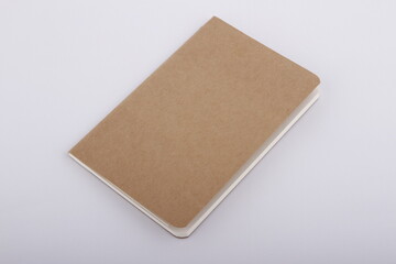 Plain unlabeled brown notebook against a white background