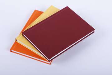 Plain blank simple thick hardbound notebooks against a white background