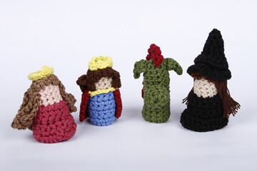 Crocheted king, queen, dragon and witch finger puppets on a white background