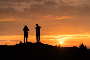 Fototapeta na wymiar Couple looking at the horizon, silhouette of a beautiful sunset