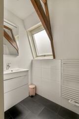 Shower faucets attached to tiled wall near glass partition and ornamental curtail in washroom at...