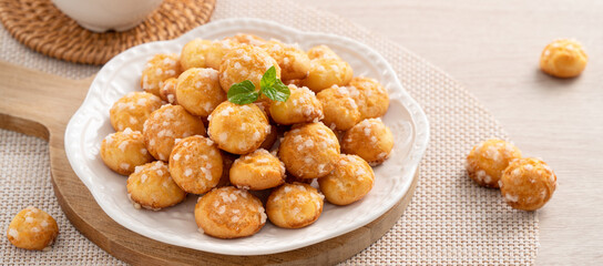 Delicious French Chouquette Choux Pastry dessert Pearl Sugar Puff on wooden table background.