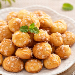 Delicious French Chouquette Choux Pastry dessert Pearl Sugar Puff on wooden table background.