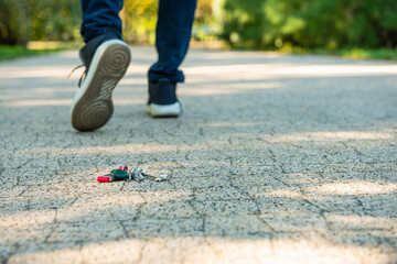 Man walking outside, focus on lost keys. Space for text