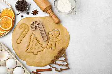 Christmas treat. Flat lay composition with cookie cutters and dough on light table, space for text