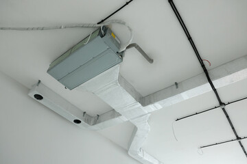 Ventilation system with pipes and wires on ceiling