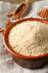 Bowl of buckwheat flour on cloth, closeup