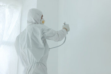 Fototapeta premium Decorator painting wall with spray, space for text