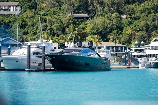 tourist boats and tour boats in the whitsundays queensland, australia. travellers on the great barrier reef, over coral and fish. tourism yachts of young people partying on the water