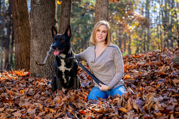 A Lovely Blonde Model Poses Outdoor While Enjoying The Fall Weather With Her Pet Dog In A Park