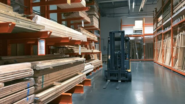 New boards and wood products lie on the shelves of the warehouse, waiting to be loaded by a forklift