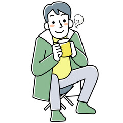アウトドアで座って飲み物を飲む若い男性