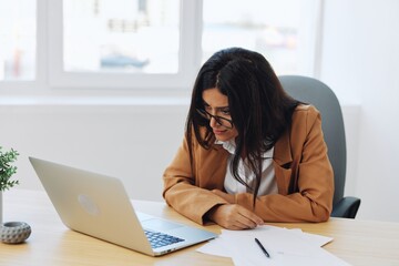 Business woman working in office at desk with laptop, anger and argument, discussing business processes online via video link, online director