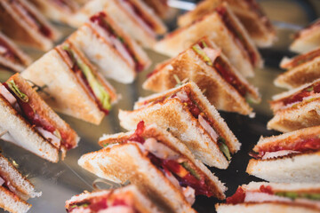 Catering table, beautifully decorated banquet table with variety of different food snacks, sandwiches, croissants and appetizers on party event or celebration, delicatessen setting, coffee break