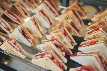 Catering table, beautifully decorated banquet table with variety of different food snacks, sandwiches, croissants and appetizers on party event or celebration, delicatessen setting, coffee break