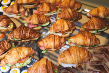 Catering table, beautifully decorated banquet table with variety of different food snacks, sandwiches, croissants and appetizers on party event or celebration, delicatessen setting, coffee break