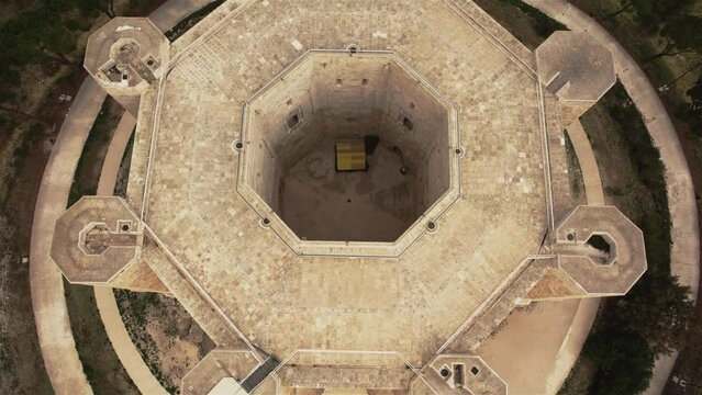 Drone flying over above Castel del Monte flying backwards with the camera tilting up in the south of Italy in 4k