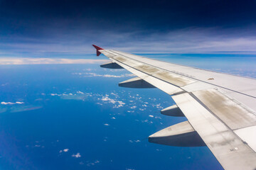 Obraz premium Airplane Wing in Flight from window, blue sky. 