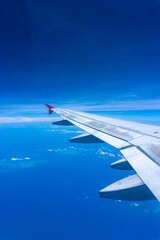 Obraz premium Airplane Wing in Flight from window, blue sky. 