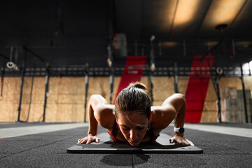 brunette caucasian girl lying on the floor on a mat doing sports in a gym