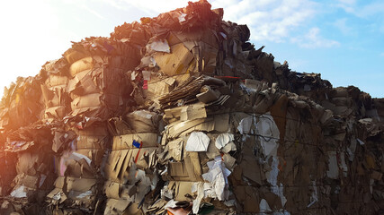 A large number of different waste paper for recycling folded at sunset outdoor.