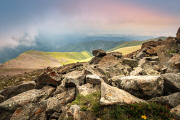 Picturesque landscape with rocky terrain on the tops of the Almaty mountains in cloudy weather. Journey through Central Asia.