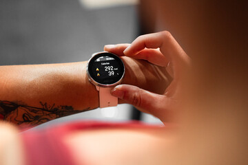 closeup left arm of young caucasian woman with smartwatch indicating calories burned after doing...